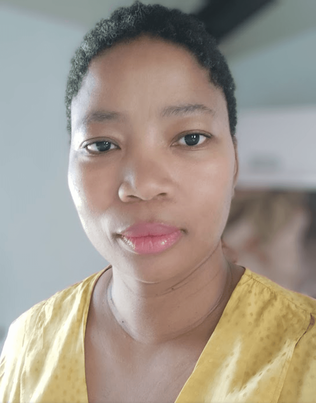 A headshot of Nyalleng, a Black woman with short hair, wearing a yellow shirt.